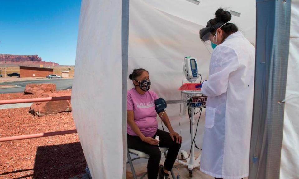 A nurse checks vitals from a woman complaining of virus symptoms in the Navajo Nation town of Monument Valley in Arizona, in May.