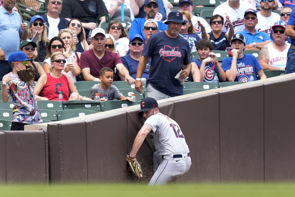 Cleveland Guardians left fielder David Fry slides into the left field wall after catching Chicago Cubs' Cody Bellinger' fly ball in foul territory during the second inning of a baseball game Friday, June 30, 2023, in Chicago. (AP Photo/Charles Rex Arbogast)