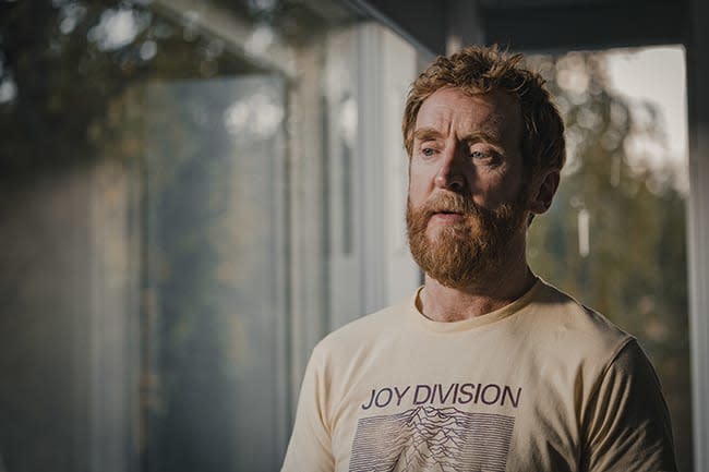 Tony Curran looks out window in Mayflies