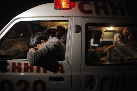 A relative (L) mourns his family member, who was killed by unknown gunmen, next to his body in an ambulance, outside the Civil Hospital morgue in Karachi February 9, 2014. REUTERS/Akhtar Soomro