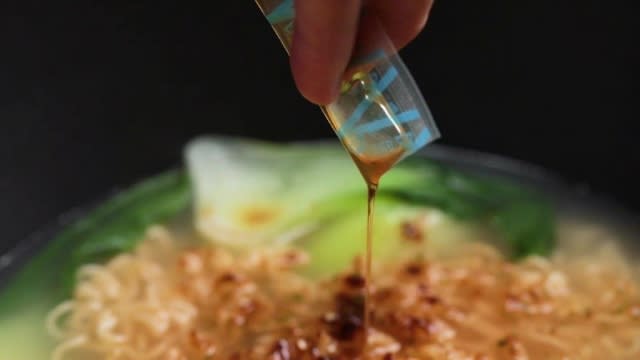 Adding seasoning sesame oil to instant noodles