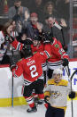 Chicago Blackhawks left wing Alex DeBrincat (12) celebrates with defenseman Duncan Keith (2) and left wing Brandon Saad after scoring the winning goal as Nashville Predators right wing Viktor Arvidsson reacts on the ice during the overtime period of an NHL hockey game in Chicago, Friday, Feb. 21, 2020. (AP Photo/Nam Y. Huh)