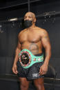 In a photo provided by Triller, Mike Tyson poses for photos after an exhibition boxing bout against Roy Jones Jr. on Saturday, Nov. 28, 2020, in Los Angeles. The bout was unofficially ruled a draw by the WBC judges at ringside. Tyson and Jones fought eight two-minute rounds, and both emerged smiling and apparently healthy from a highly unusual event. (Joe Scarnici/Triller via AP)