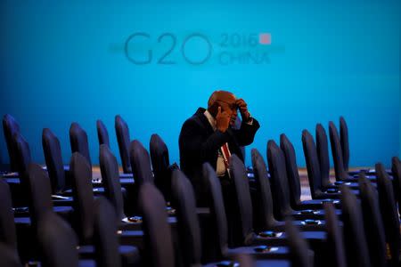 An attendee talks on his phone before the opening ceremony of the 2016 G20 Trade Ministers Meeting in Shanghai, China July 9, 2016. REUTERS/Aly Song