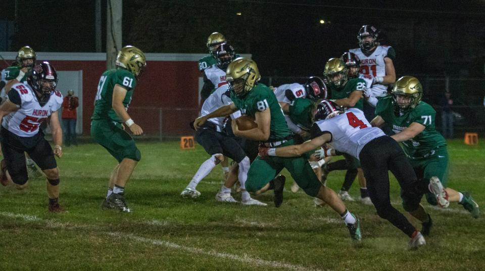 St. Mary Catholic Central's Carson Kinsey (81) tries to break a tackle by Ashton Warren of New Boston Huron Friday night. Huron won 33-6.