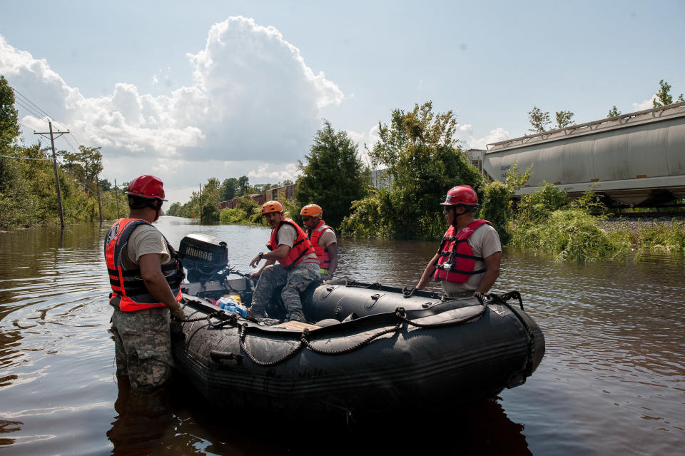 Troops about to drive down the flooded road in Rose City to check the current to make sure their vehicles can make it.