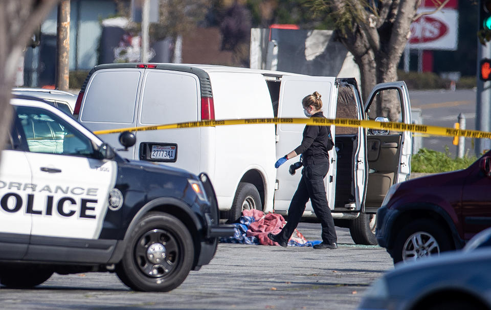 Torrance, CA - January 22:  A coroner official investigates the scene where police say a man slumped over the wheel of a white van, apparently deceased due to a self-inflicted gunshot, is connected to Saturday nights Lunar New Year mass shooting in Monterey Park. Torrance SWAT officers surrounded the van as the driver appeared slumped over the wheel in Torrance Sunday, Jan. 22, 2023. At least two bullet holes had been visible in the drivers-side window. Just before 1 p.m. Sunday, a SWAT team swarmed the vehicle and smashed its windows in the parking lot of Tokyo Central, a Japanese grocery store near the southwest corner of Hawthorne and Sepulveda boulevards.  (Allen J. Schaben / Los Angeles Times via Getty Images)