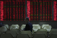 A man looks back as he monitors the stock prices at a brokerage house in Beijing, Wednesday, Jan. 9, 2019. Shares extended gains in Asia on hopes for progress in resolving the tariffs battle between the U.S. and China as talks appeared to have been extended in Beijing. (AP Photo/Andy Wong)