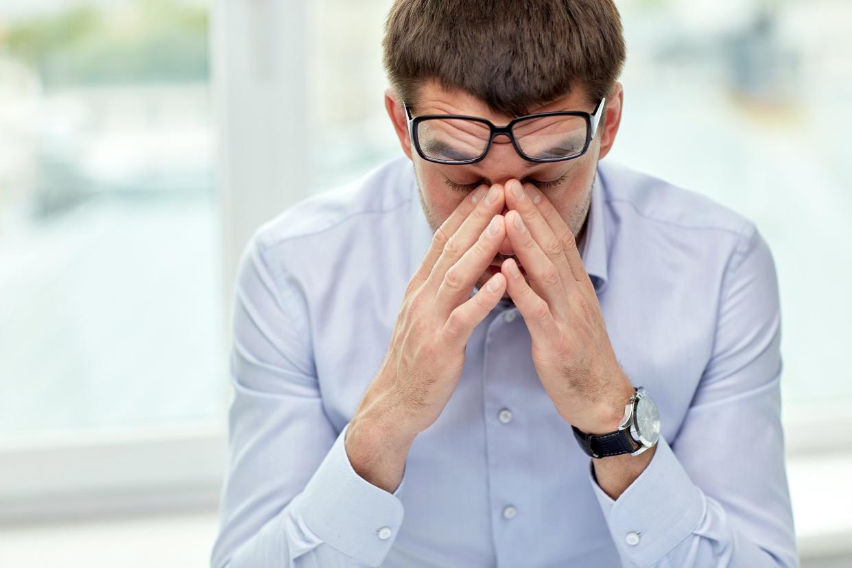 stressed businessman with eyeglasses in office