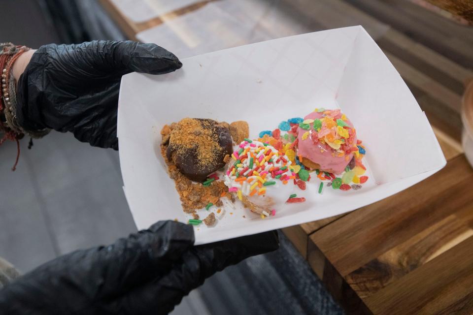 Tammy Tucker, co-owner of Coastal Mini Donuts, prepares a sampling of the store's signature convections on Tuesday, May 10, 2022. Coastal Donuts is now open on West Nine Road.