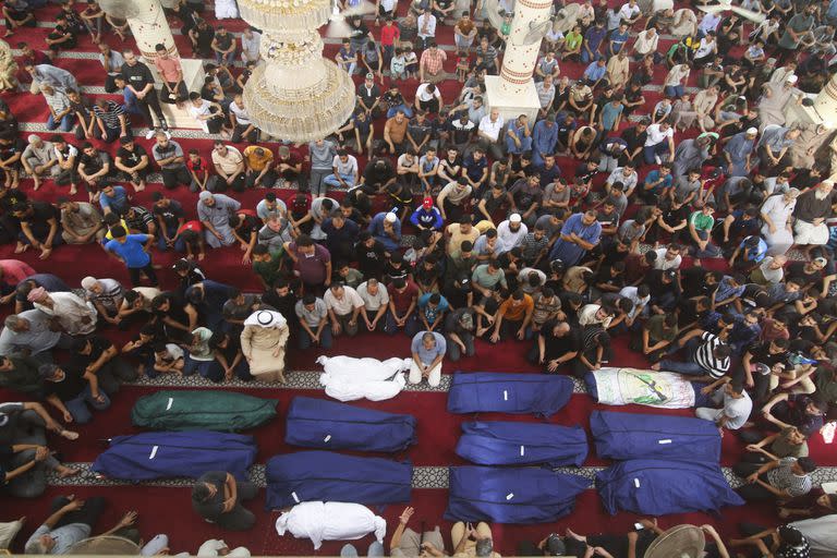 Personas rezan ante los cuerpos de la familia de un combatiente de Hamas, después de que fueron asesinados en un ataque israelí contra su casa en el sur de la Franja de Gaza