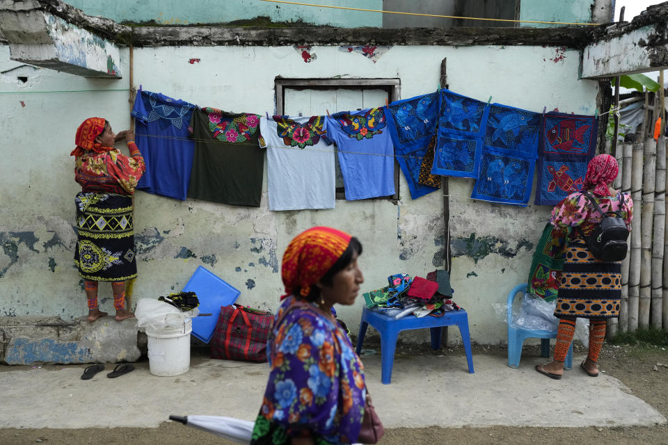 Mujeres exhiben vestidos tradicionales para la venta a turistas en la isla Gardí Sugdub, parte del archipiélago de San Blas frente a la costa caribeña de Panamá, el domingo 26 de mayo de 2024. Debido al aumento del nivel del mar, unas 300 familias indígenas Guna se trasladarán a nuevas casas, construidas por el gobierno, en tierra firme. (Foto AP/Matías Delacroix)