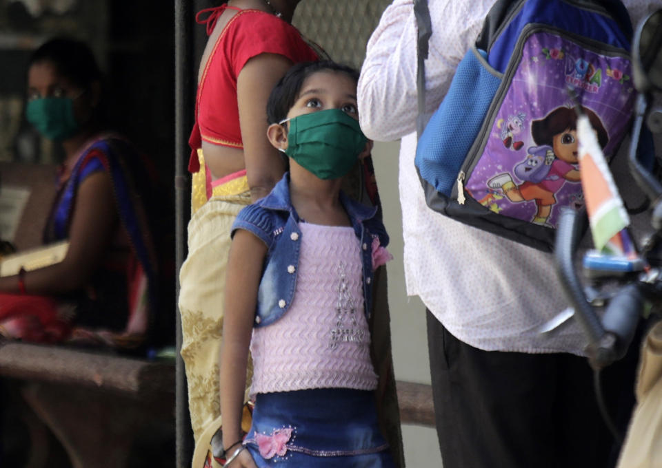 A child wears a mask and walks in a hospital that also has a special ward set aside for possible COVID-19 patients, in Mumbai, India, Thursday, March 5, 2020. A new virus first detected in China has infected more than 90,000 people globally and caused over 3,100 deaths. The World Health Organization has named the illness COVID-19, referring to its origin late last year and the coronavirus that causes it. (AP Photo/Rajanish Kakade)