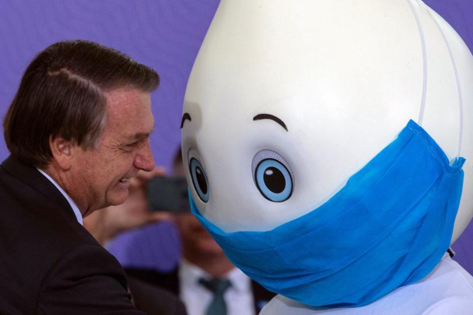 Bolsonaro poses with the Covid vaccine mascot Ze Gotinha in Brasilia (EPA-EFE)