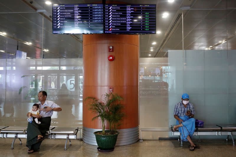 People wear face masks at the arrival hall of Yangon international airport in Yangon
