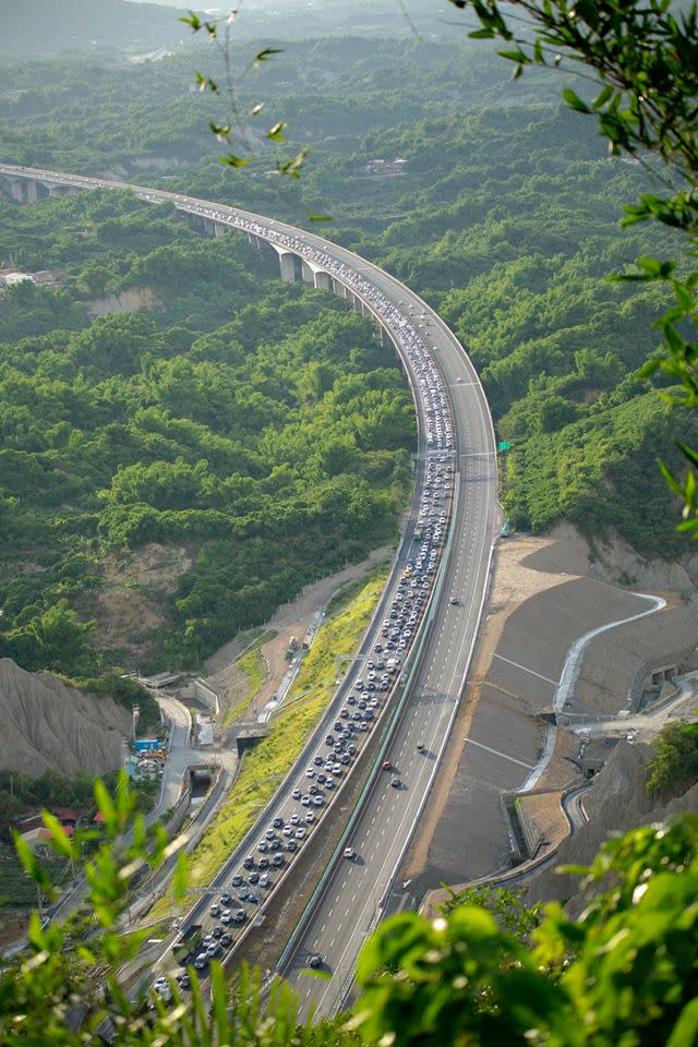 畫面中，視角由高處向下拍攝，一條蜿蜒的高速公路上，密密麻麻的擠滿車輛。（圖／翻攝自爆廢公社）