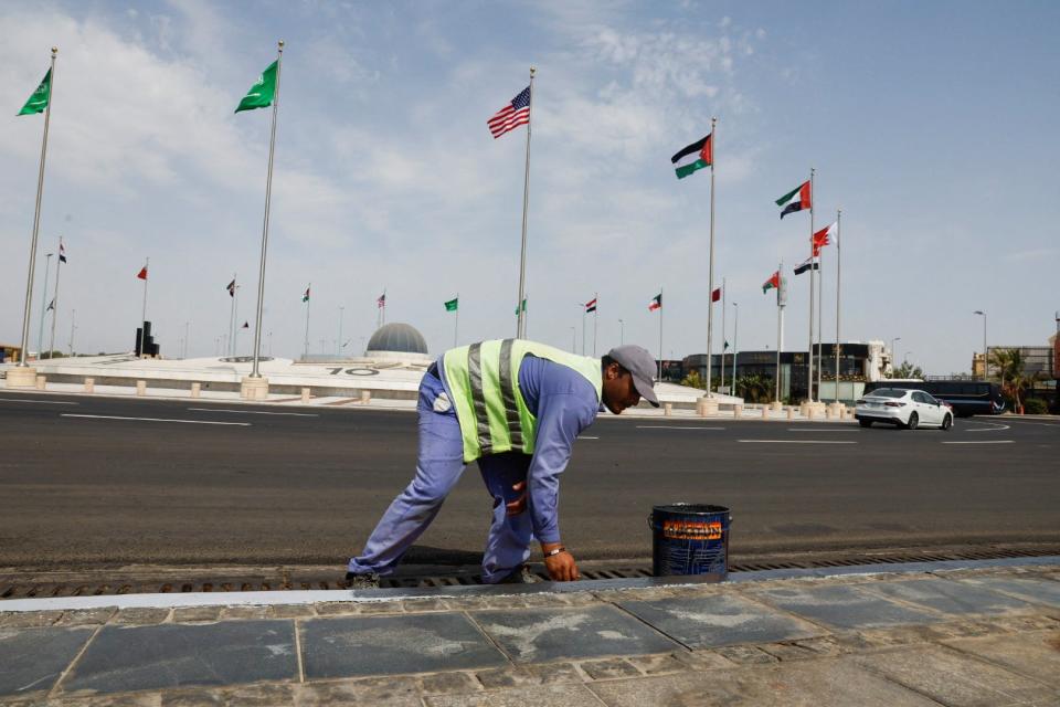 A worker cleans the road as part of the preparations for US president Joe Biden’s visit, in Jeddah, Saudi Arabia 14 July 2022 (Reuters)