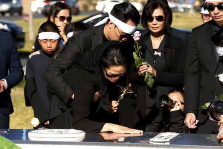 Van Thanh Nguyen (C) touches the burial vault of her daughter, San Bernardino shooting victim Tin Nguyen, during her funeral at Good Shepherd Cemetery in Huntington Beach, California December 12, 2015. REUTERS/Patrick T. Fallon -