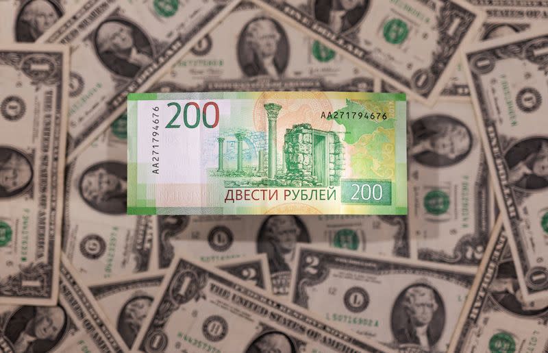 FILE PHOTO: Illustration shows Russian Rouble banknote is placed on U.S. Dollar banknotes