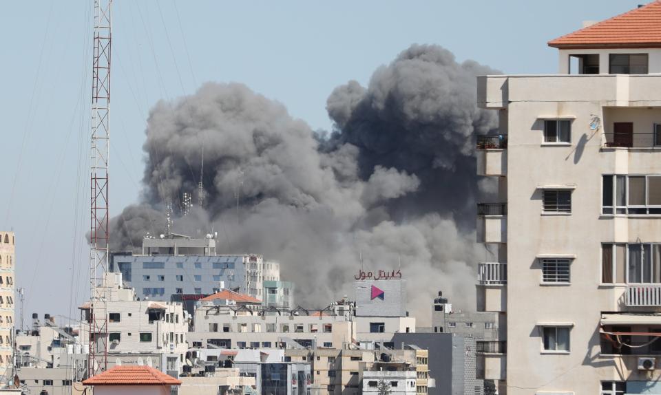 <p>Smoke rises after Israeli forces destroyed building in Gaza City where Al-Jazeera and Associated Press had their offices, on Saturday (15 May)</p> (Anadolu Agency/Getty)