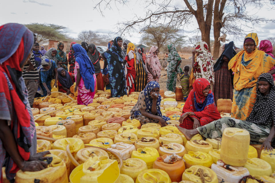 Kenyan women of Somali origin wait with their containers for a water distribution from the government near Kuruti, in Garissa County, Kenya Wednesday, Oct. 27, 2021. As world leaders address a global climate summit in Britain, drought has descended yet again in northern Kenya, the latest in a series of climate shocks rippling through the Horn of Africa. (AP Photo/Brian Inganga)