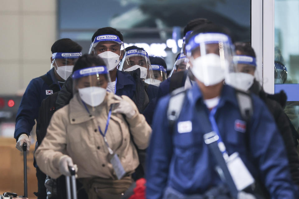 FILE - Passengers wearing face masks and face shields amid the coronavirus pandemic arrive at the Incheon International Airport in Incheon, South Korea, Nov. 30, 2021. South Korea’s daily jump in coronavirus infections exceeded 5,000 on Wednesday, Dec. 1, for the first time since the start of the pandemic, as a delta-driven surge also pushed hospitalizations and deaths to record highs. (Lim Hwa-young/Yonhap via AP, File)