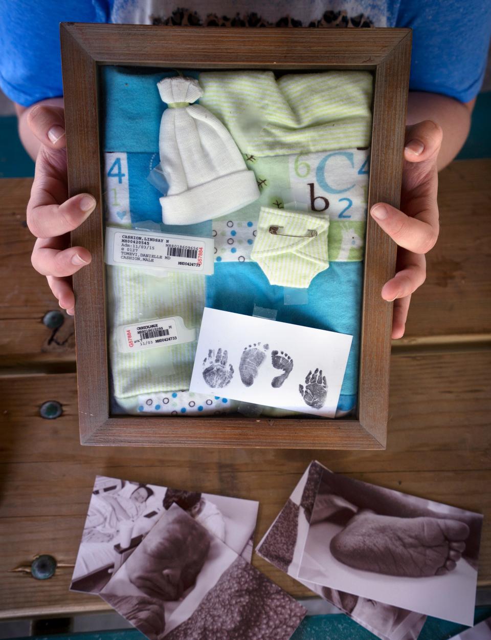 Lindsay Cashion shows a baby box with mementos of her late son, Mason, Tuesday, July 5, 2022 in Carbondale, Ill. Mason was shown to have many health issues, in utero, indicating he would die, said Cashion, so she sought abortion services. She was 19 in Nov. 2015, when she was induced and had Mason. She doesn't consider the procedure an abortion because she delivered him. But such services would not be available in some places because of the latest abortion law changes.