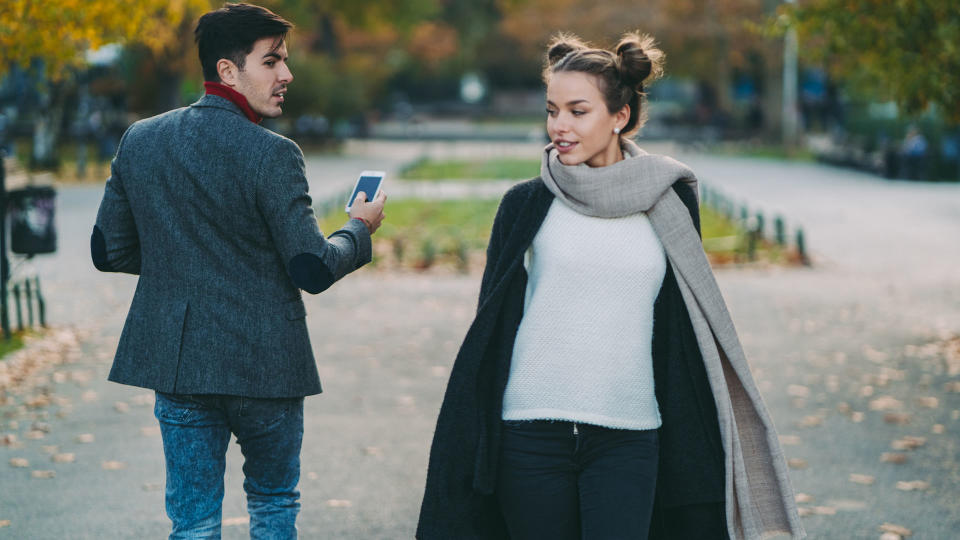 Young man staring at a beautiful woman in the city park