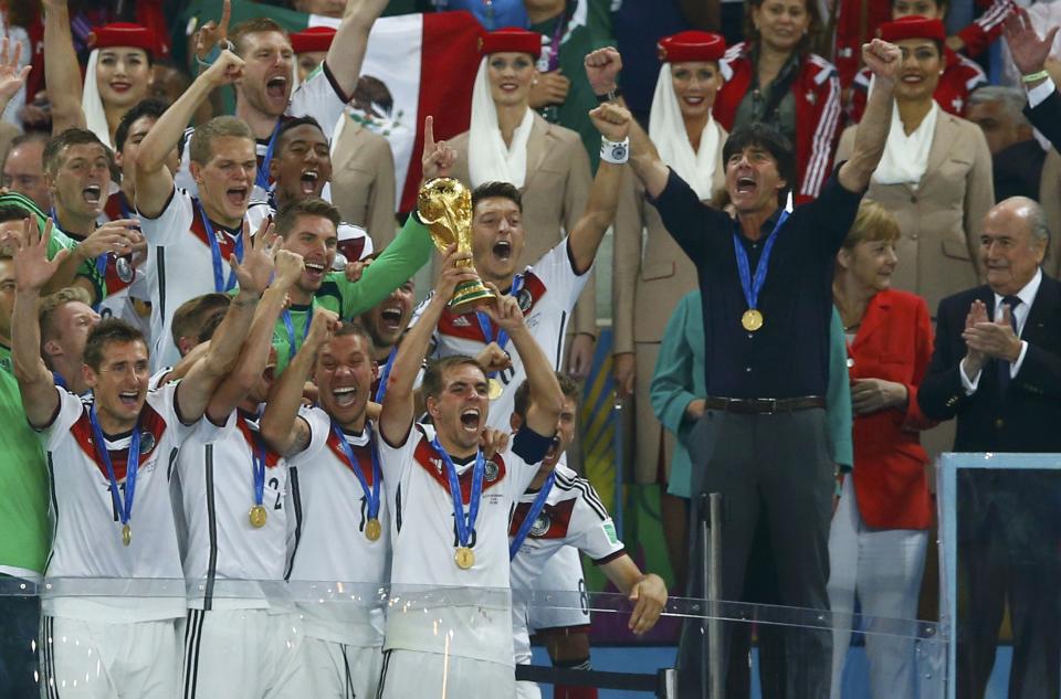 Germany's captain Lahm lifts near coach Loew the World Cup trophy after the 2014 World Cup final against Argentina at the Maracana stadium in Rio de Janeiro