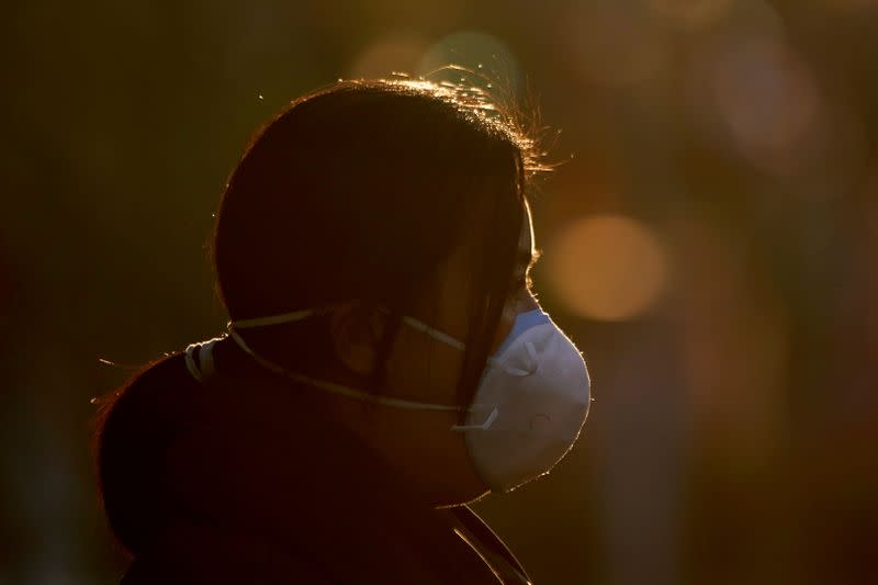 A woman wearing a mask is seen on a street in Shanghai, China, as the country is hit by an outbreak of a new coronavirus