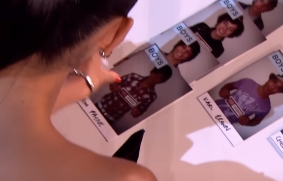 Nicole placing Liam's photo beneath the previous three