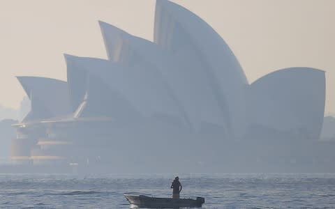 Sydney Opera House as winds blow smoke from bushfires - Credit: STEVEN SAPHORE/AAP