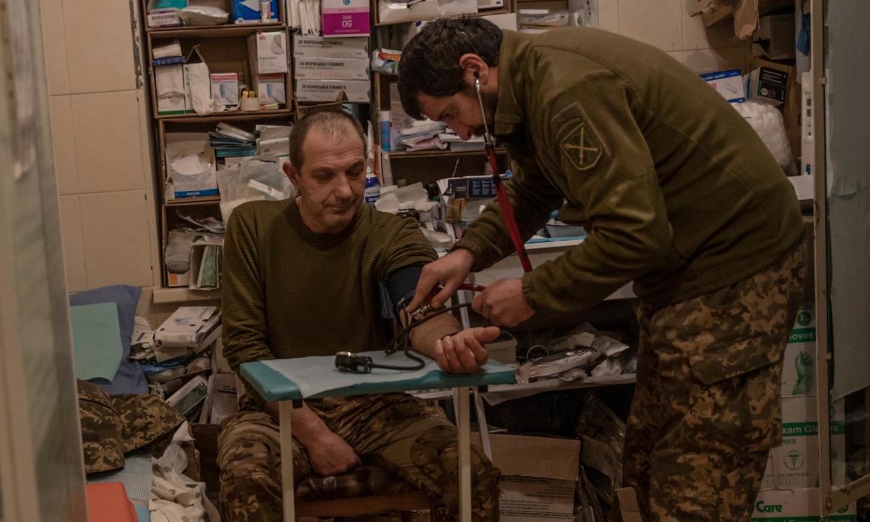 <span>Vitalii Harnik treats a soldier, Andrii, at a hospital in the Donetsk region. Andrii was concussed when a Russian drone dropped a bomb into his foxhole.</span><span>Photograph: Alessio Mamo/The Guardian</span>