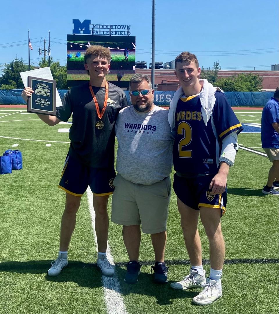 Our Lady of Lourdes boys lacrosse coach Chris Malet is flanked by team captains Drew Cornax, left, and Matthew Krauza, right, after winning the Section 9 Class C championship on May 27, 2023.