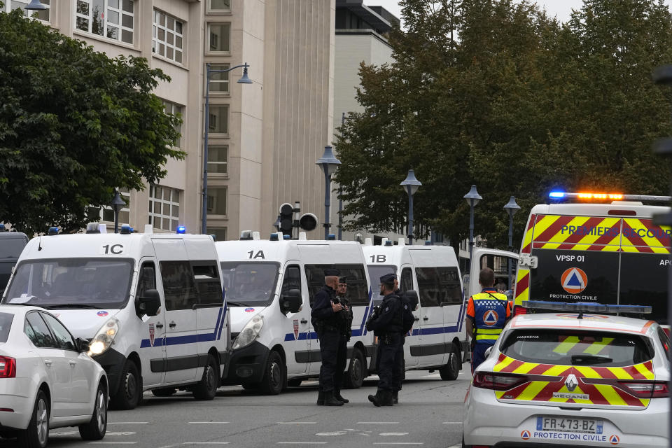 Police officers and rescue workers stand by the Gambetta high school after a man armed with a knife killed a teacher and wounded two others in Arras, northern France, Friday, Oct. 13, 2023. Antiterror prosecutors said they were leading the investigation into the attack at the Gambetta high school in the city of Arras, some 115 miles (185 kilometers) north of Paris. (AP Photo/Michel Euler)