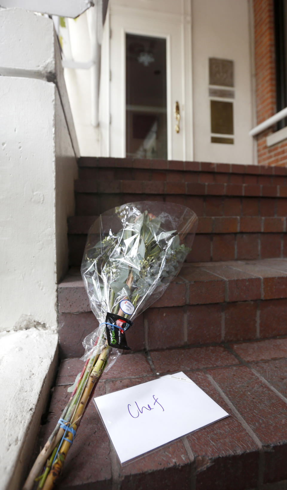 A card addressed to Chef, and a bouquet of flowers rest on the stairs to Charlie Trotter's permanently closed Chicago restaurant after reports of the chef's death Tuesday, Nov. 5, 2013, in Chicago. Trotter, 54, an award-winning chef, was a self-taught culinary master whose eponymous Chicago restaurant elevated the city’s cuisine and provided a training ground for some of the nation’s other best chefs. (AP Photo/Charles Rex Arbogast)