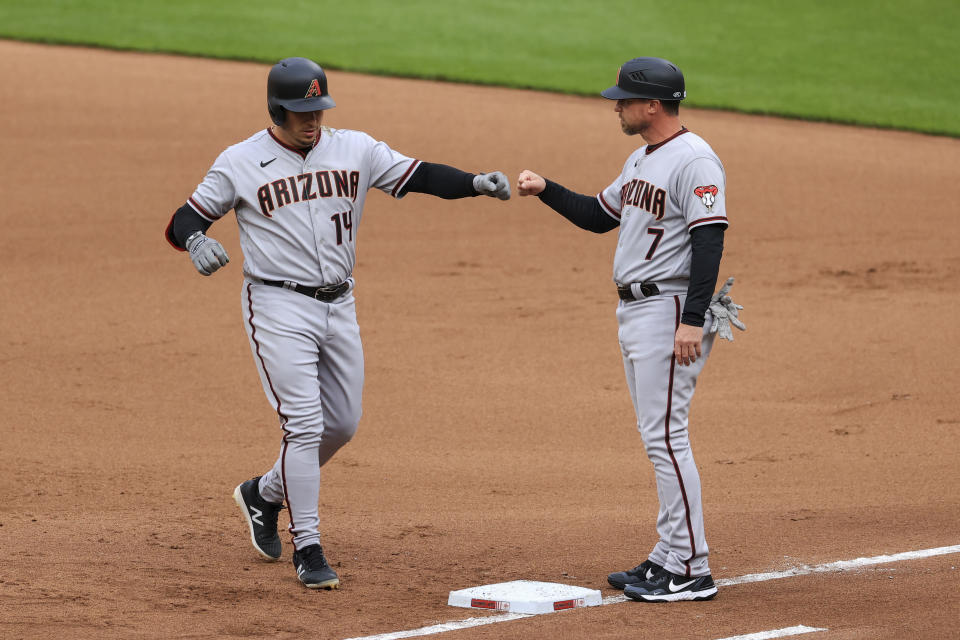 Arizona Diamondbacks' Asdrubal Cabrera, left, fist-bumps Robby Hammock after hitting an RBI single during the first inning of the team's baseball game against the Cincinnati Reds in Cincinnati, Tuesday, April 20, 2021. (AP Photo/Aaron Doster)