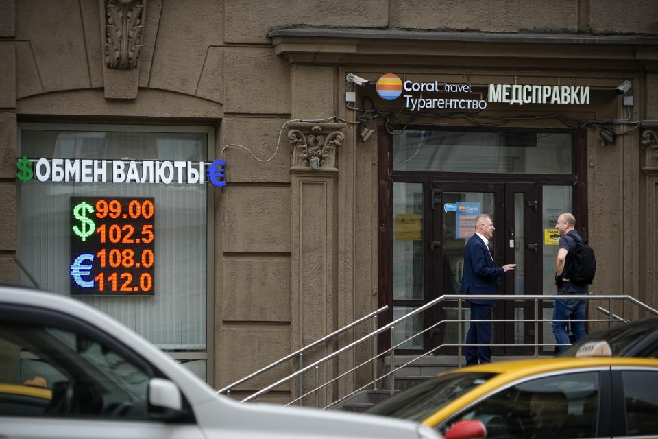 Two men talk to each other at the entrance of a currency exchange office in Moscow, Russia, Monday, Aug. 14, 2023. The Russian ruble has reached its lowest value since the early weeks of the war in Ukraine as Western sanctions weigh on energy exports and weaken demand for the national currency. The Russian currency passed 101 rubles to the dollar on Monday, continuing a more than 25% decline in its value since the beginning of the year. (AP Photo/Alexander Zemlianichenko)