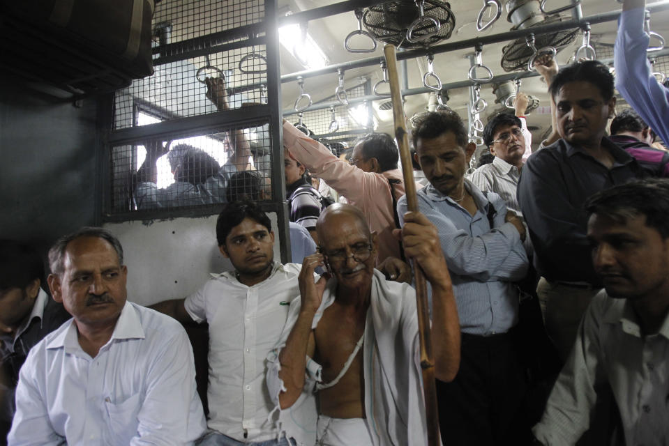 Mahesh Chaturvedi, who dresses up like Mahatma Gandhi, talks on the phone in the outskirts of New Delhi