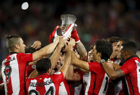 Athletic Bilbao's players raise up the Spanish Super Cup trophy after defeating Barcelona at Camp Nou stadium in Barcelona, Spain August 17, 2015. REUTERS/Albert Gea