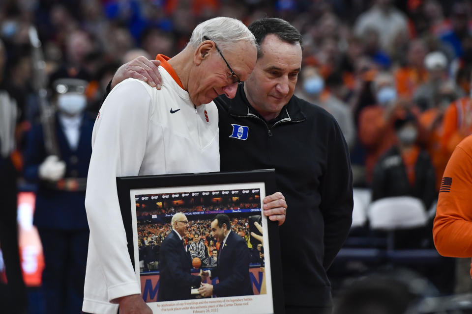 Syracuse coach Jim Boeheim, left, presents Duke coach Mike Krzyzewski with a gift before an NCAA college basketball game in Syracuse, N.Y., Saturday, Feb. 26, 2022. (AP Photo/Adrian Kraus)