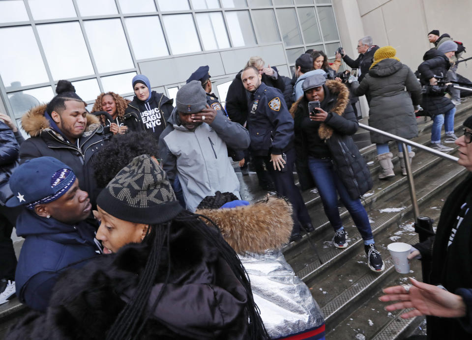 Protesters and family members of prisoners wipe their eyes and cry after they and others stormed the main entrance of the Metropolitan Detention Center, Sunday, Feb. 3, 2019, in New York, where prisoners haven't had access to heat, hot water, electricity or sanitary conditions since earlier in the week, including throughout the recent frigid cold snap. (AP Photo/Kathy Willens)