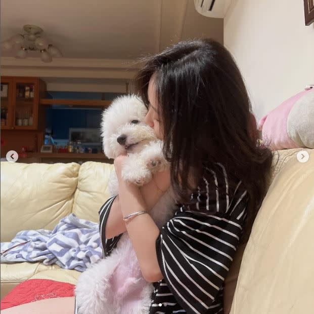 陳紫渝在客廳沙發上緊抱愛犬，並「強吻」了狗狗的臉頰。（圖／翻攝自陳紫渝IG）
