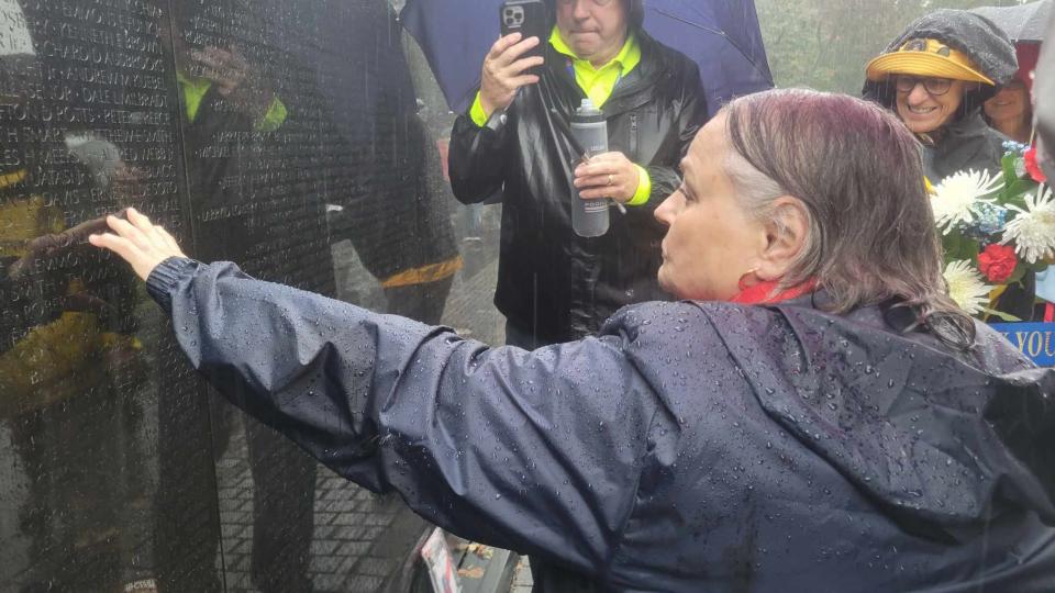 Julia Coffey, the widow of Capt. Frederick Hall of Waynesville, touches his name at the Vietnam War Memorial wall on Oct. 14.