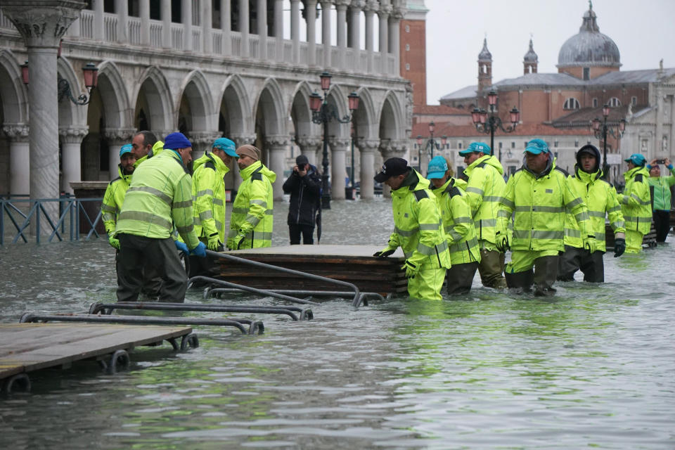 Workers install trestle bridge as high water floods Venice, northern Italy, Sunday, Nov. 24, 2019. The high water reached peak of 135cm (4.42ft) early Sunday. (Andrea Merola/ANSA via AP)