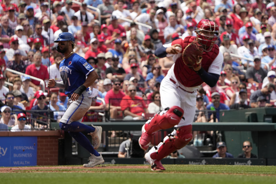 St. Louis Cardinals catcher Willson Contreras, right, throws out Kansas City Royals' Freddy Fermin at first as Royals' MJ Melendez, left, scores on a sacrifice bunt by Fermin during the fifth inning of a baseball game Monday, May 29, 2023, in St. Louis. (AP Photo/Jeff Roberson)