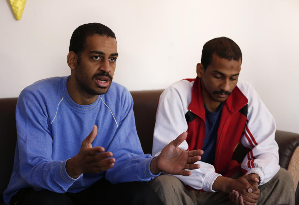 FILE - In this March 30, 2019, file photo, Alexanda Amon Kotey, left, and El Shafee Elsheikh, who were allegedly among four British jihadis who made up a brutal Islamic State cell dubbed "The Beatles," speak during an interview with The Associated Press at a security center in Kobani, Syria, Friday, March 30, 2018. The men said that their home country's revoking of their citizenship denies them a fair trial. "The Beatles" terror cell is believed to have captured, tortured and killed hostages including American, British and Japanese journalists and aid workers. (AP Photo/Hussein Malla, File)