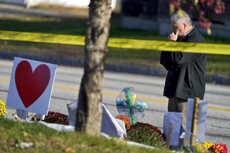 A community member looks at a memorial outside Schemengees Bar & Grille, Friday, Nov. 3, 2023, Lewiston, Maine. President Joe Biden is heading to Lewiston to mourn with the community after 18 people were killed in the deadliest mass shooting in state history. (AP Photo/Matt York)