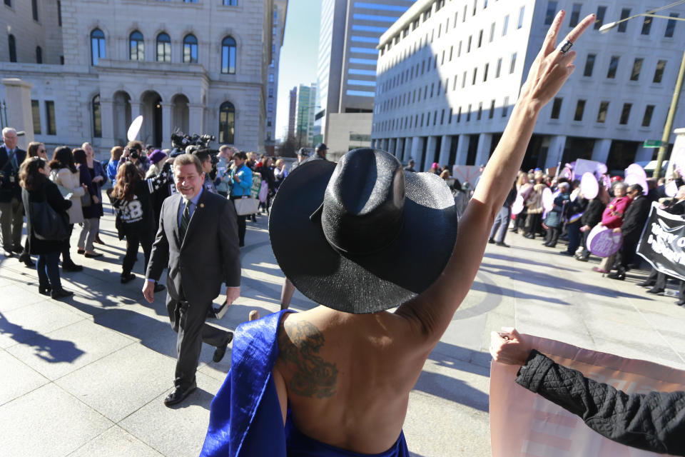 Equal Rights Amendment supporter, Sister Leona, dressed like the goddess Virtue wrapped in the Virginia State Flag greets legislators as they arrive for the 2020 session outside Virginia State Capitol in Richmond, Va., Wednesday, Jan. 8, 2020. (AP Photo/Steve Helber)