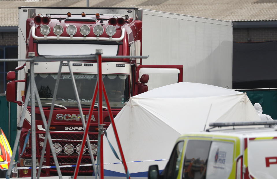 The scene after a truck, in rear, was found to contain a large number of dead bodies, in Thurrock, South England, early Wednesday Oct. 23, 2019. Police in southeastern England said that 39 people were found dead Wednesday inside a truck container believed to have come from Bulgaria. (AP Photo/Alastair Grant)